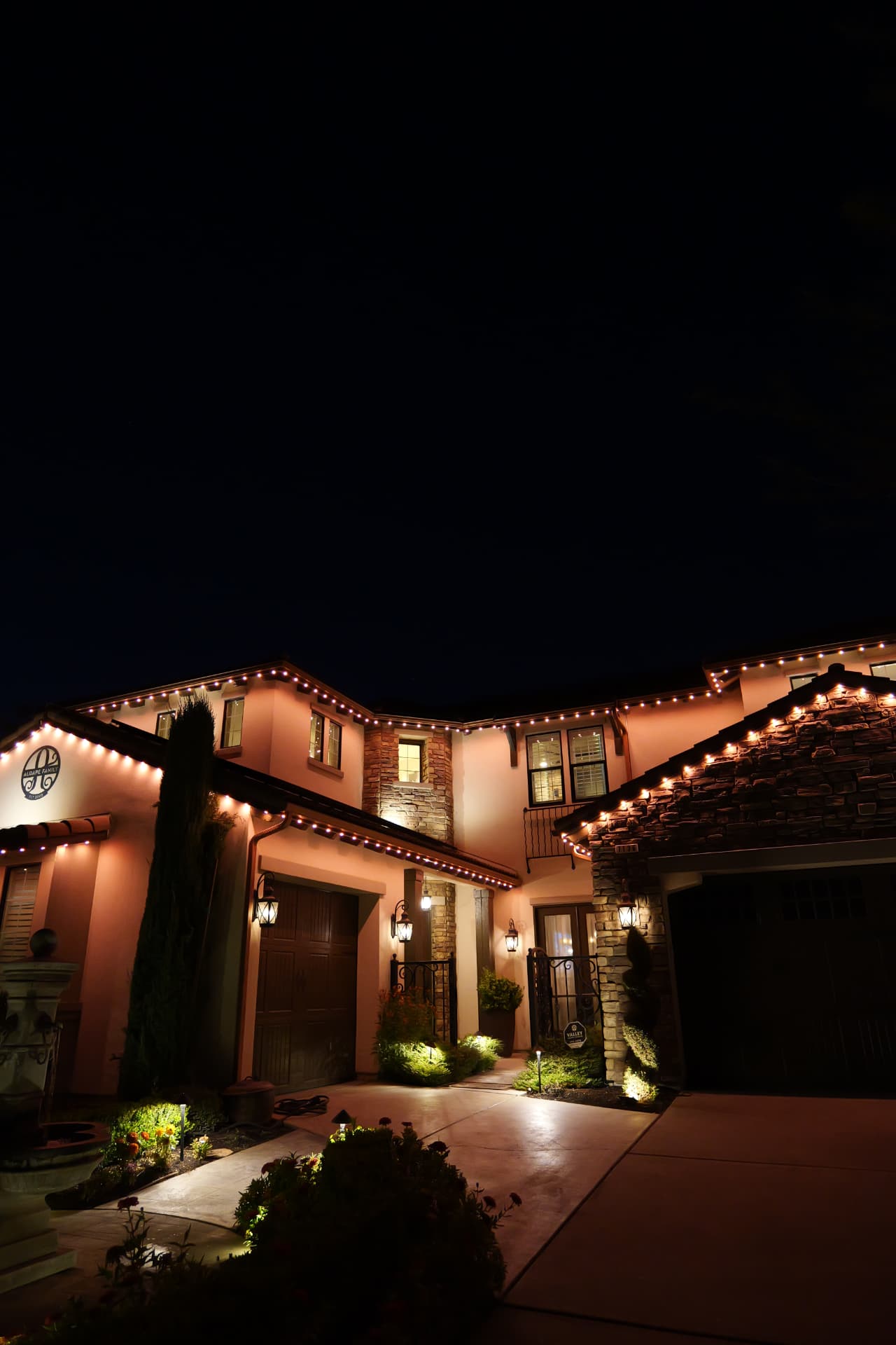 Two-story stucco home wrapped in warm-white bluEmber roofline lighting