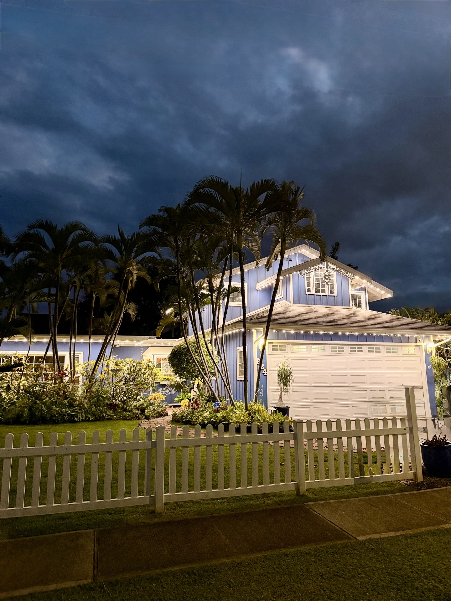 Hawaiian plantation-style home framed by palms with warm-white bluEmber eave lighting